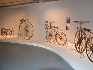 Runde Ausstellungswand mit verschiedenen antiken Fahrrädern 