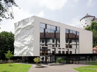 Modernes Gebäude mit einer auffälligen, knitterartig gestalteten weißen Wand