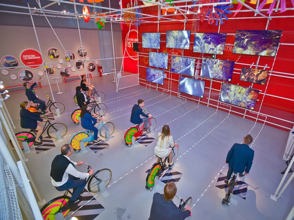 Menschen nutzen bunte Fahrräder in einer interaktiven Ausstellung