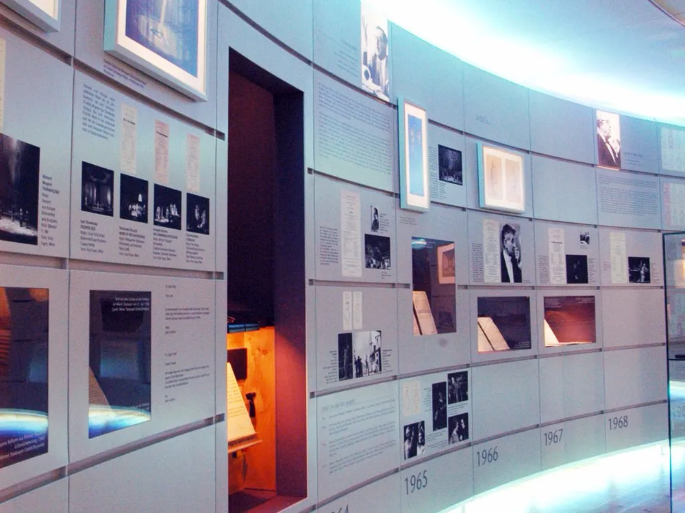 Nahansicht auf Wand mit integrierten Vitrinen, Fotos und Texten