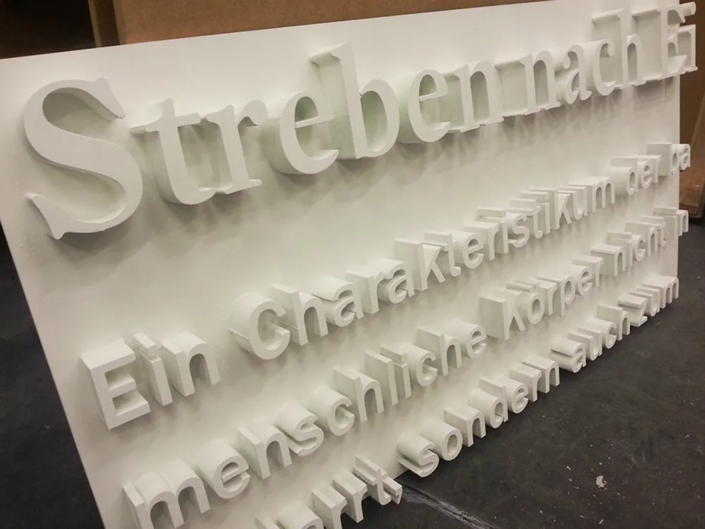 Längerer Text in 3D Schrift an weißer Platte