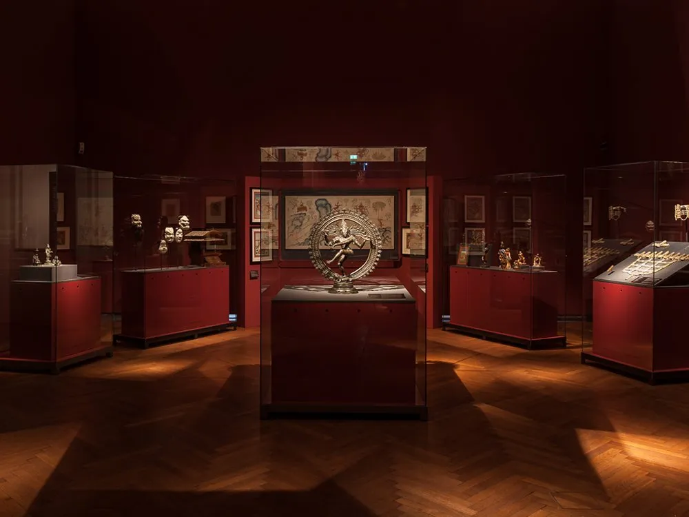 Ausstellungsraum: zentral eine Vitrine mit Nataraja-Statue, umgeben von Vitrinen mit Masken und Kunstwerken