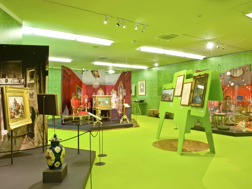 Ausstellungsraum: Vitrinen voller antiker Vasen und Statuen, Wandbilder mit mythologischen Szenen