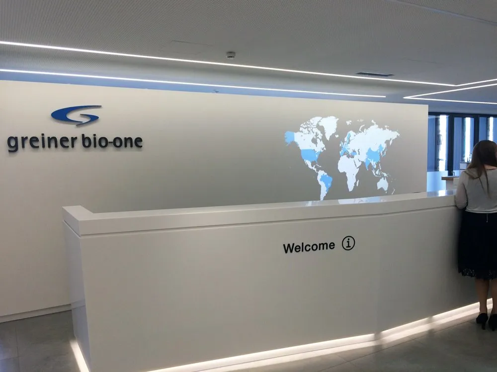 Empfangstresen mit "Greiner bio-one" Logo und Weltkarte im Hintergrund