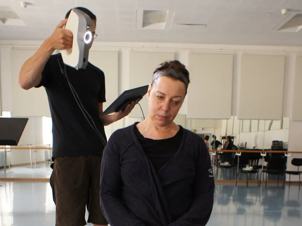 Person wird mit 3D-Scanner gescannt, heller Raum mit Spiegeln