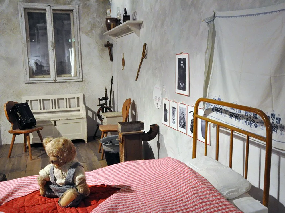Ausstellungsraum: Biedermeier-Zimmer mit Bett, Teddybär und weiteren Möbeln