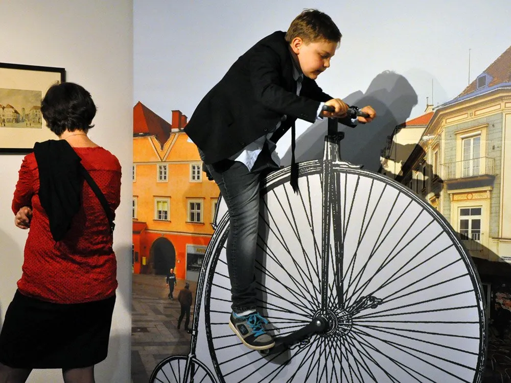 Kind auf einer Nachbildung eines Hochrads