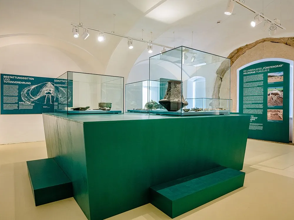 Detailansicht: Grüne Vitrine mit antiken Artefakten