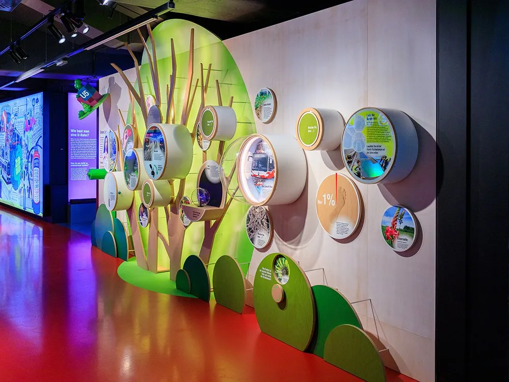 Rechte seitliche Ansicht auf runde Vitrinen an der Wand und baumförmigen Display