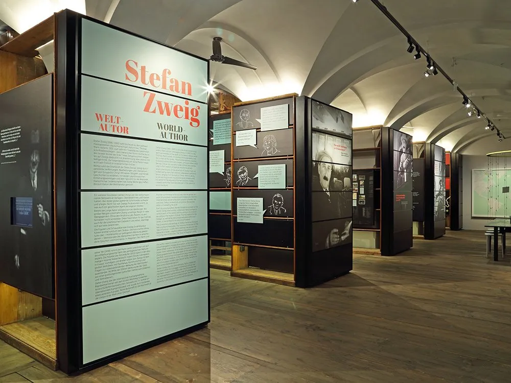Ausstellungsraum mit schwarzen Vitrinen mit Texten und Bildern über Stefan Zweig, sowie einem großen Schild mit dem Titel „Stefan Zweig – Weltautor“.