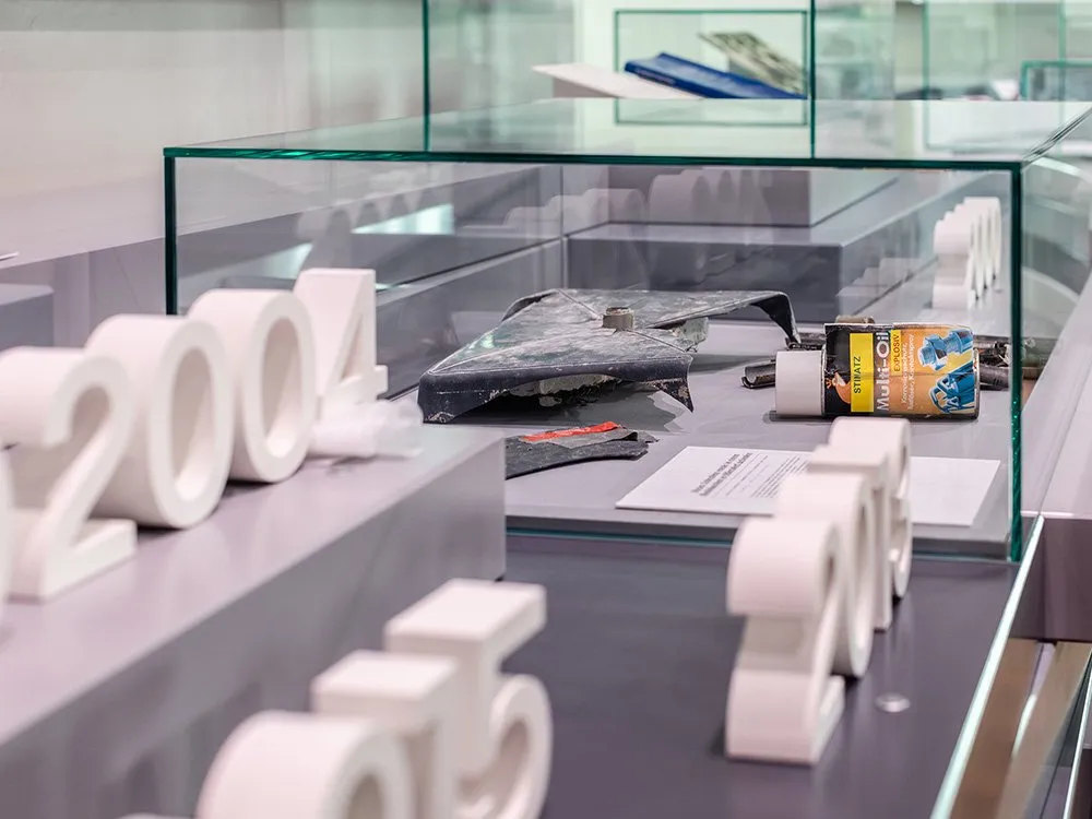 Moderne Vitrine mit Exponaten umgeben von großen weißen Jahreszahlen