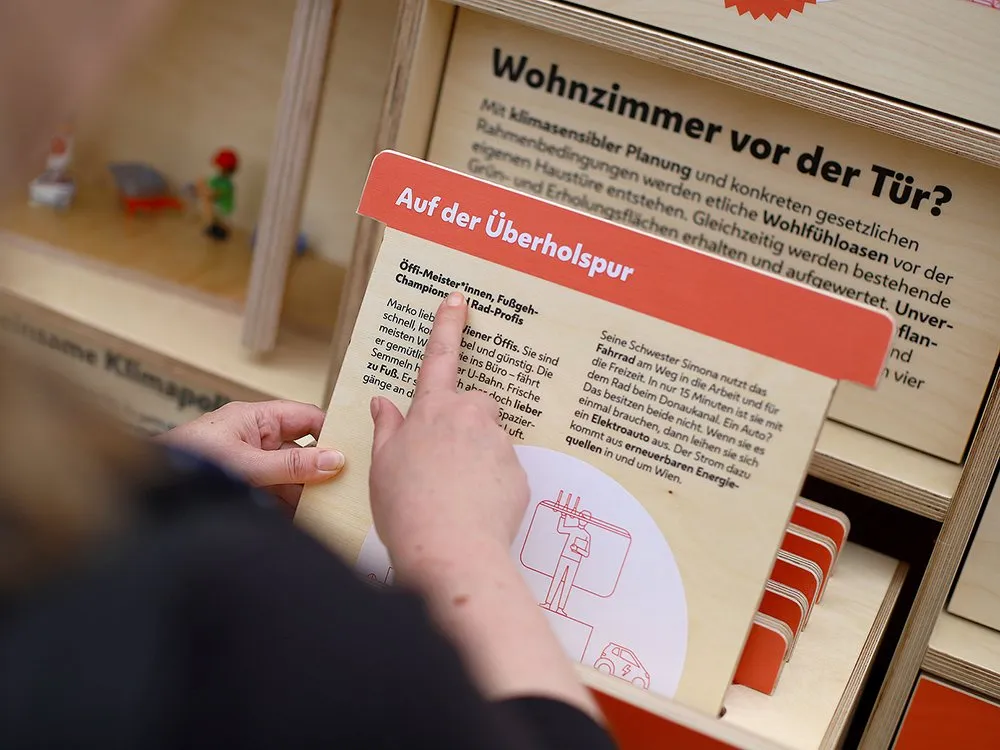 Detailansicht: Holzkarte mit Infografik und Text über Nutzung öffentlicher Verkehrsmittel.