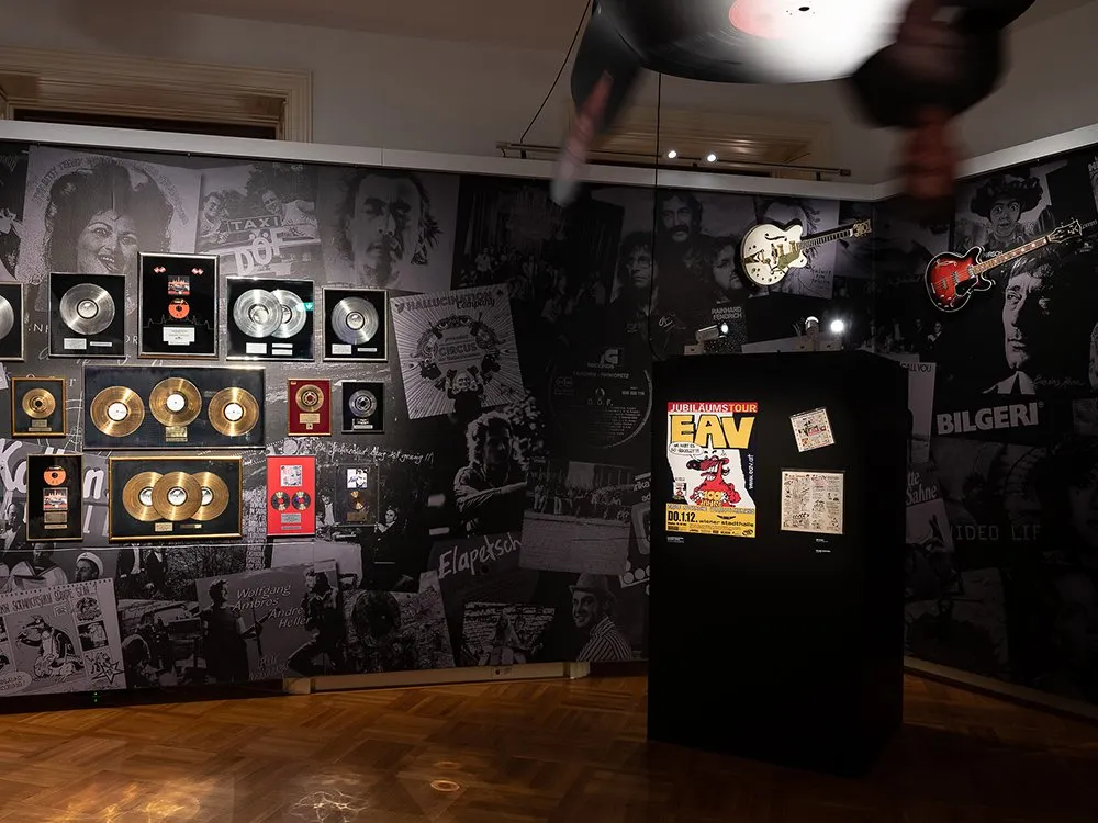 Wand voller Platten, Gold- und Platinschallplatten sowie alten Plakaten und Fotos