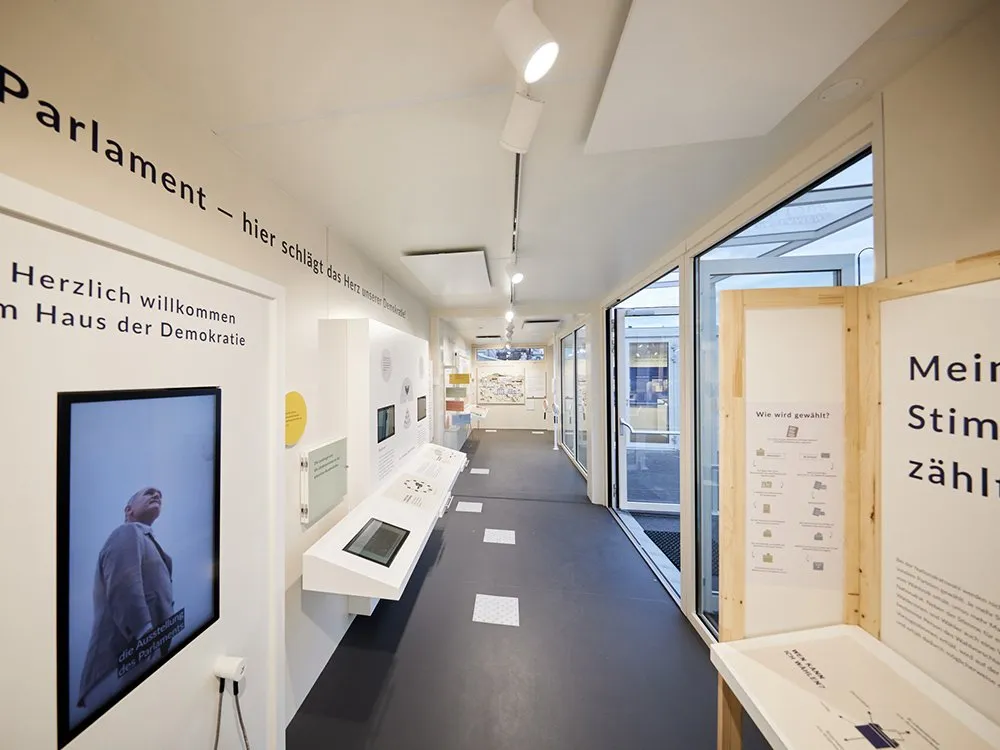 Ausstellung mit Texttafeln, Touchscreens und einem Stadtplan, aus einer weitwinkeligen Perspektive