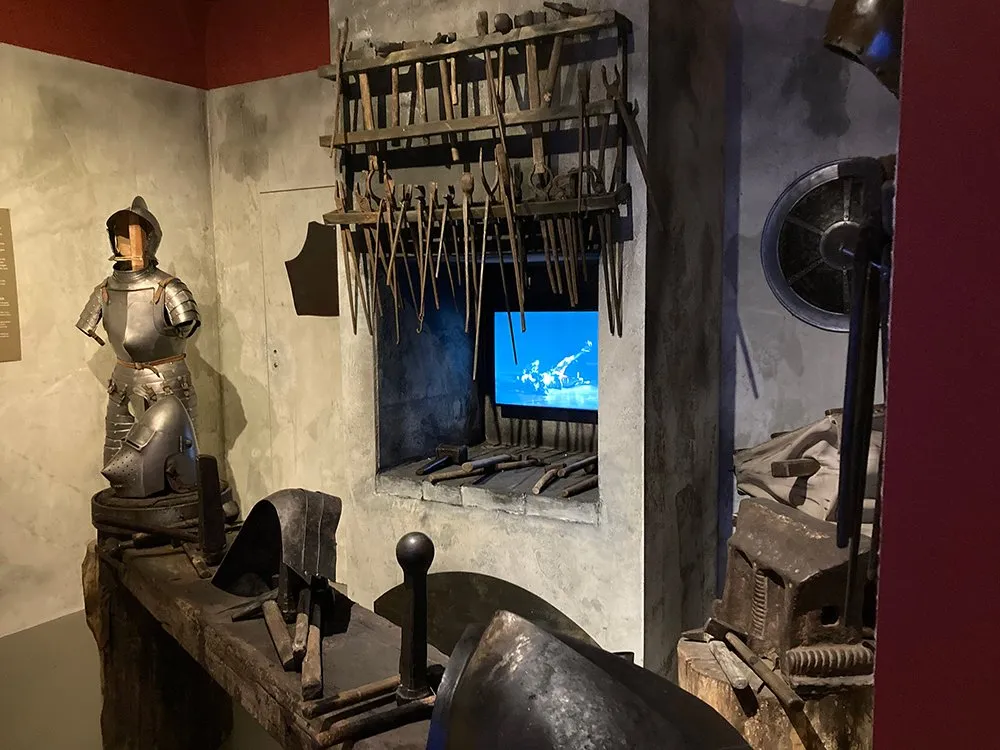 Mittelalterlicher Raum mit Ritterrüstung in der Ecke.