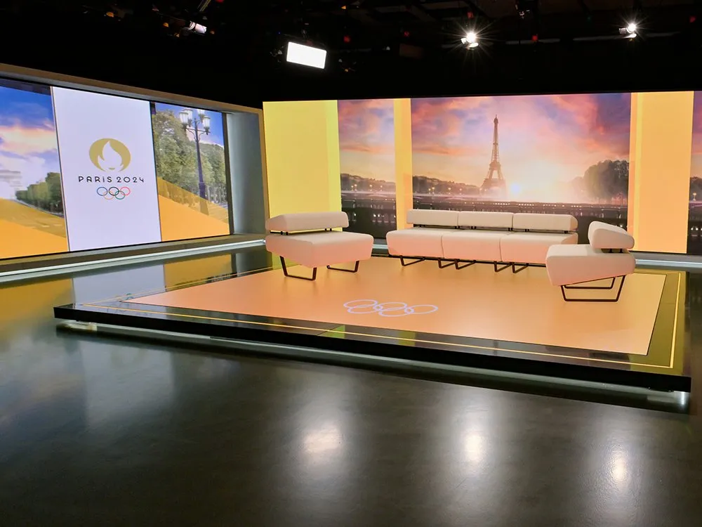 Studio mit LED-Wänden, die Olympia Paris 2024 Logo und den Eiffelturm bei Sonnenuntergang zeigen