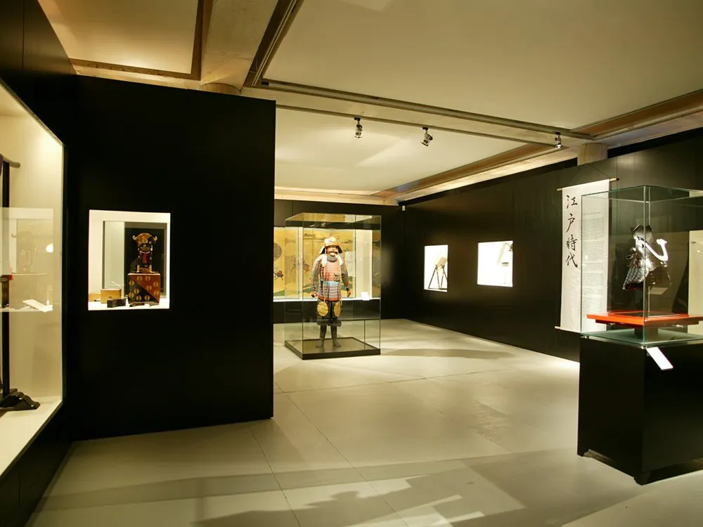 Ausstellungsraum: Samurai Rüstung in Vitrine, Bilder und Texte an den Wänden