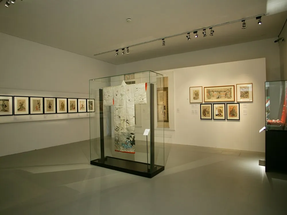 Ausstellungsraum: Vitrine mit antiken Kimono, Bilder an den Wänden