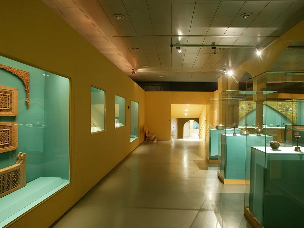 Ausstellungsraum mit eingebauten Vitrinen an Wand, freistehende Vitrinen im Raum, mit historischen Artefakten