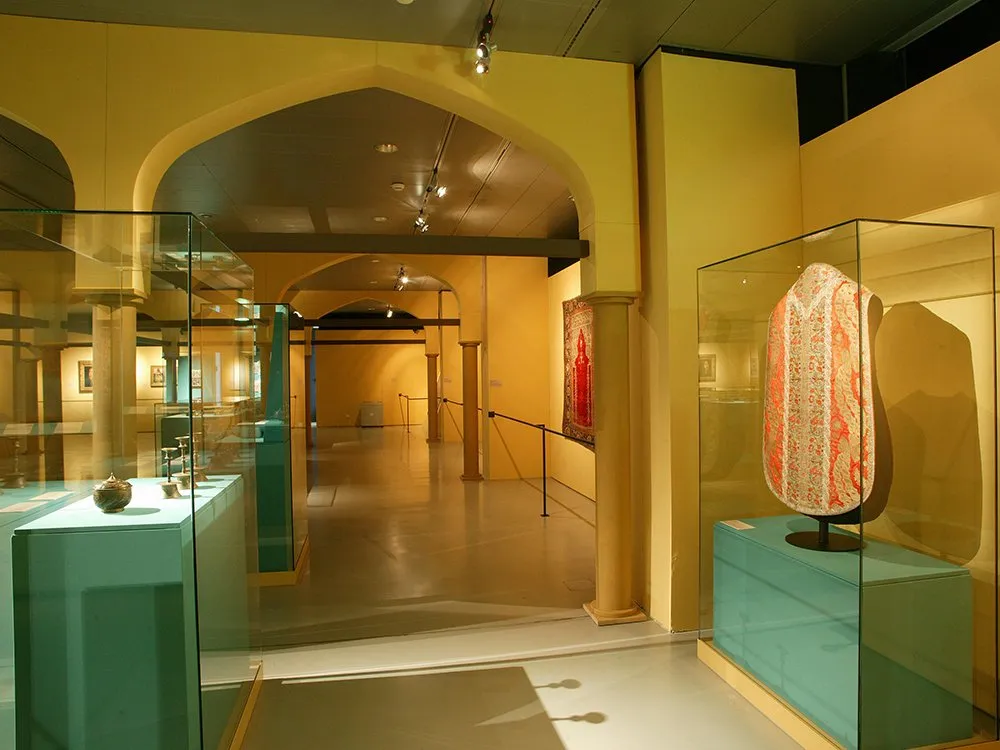 Vitrinen mit goldenen Artefakten und rot-goldener Robe