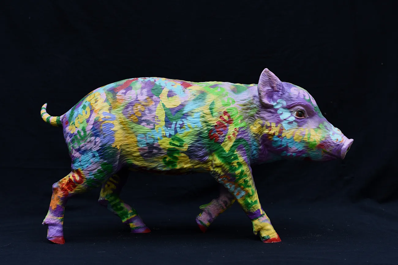 Bunt bemaltes Schwein mit Schriftzügen