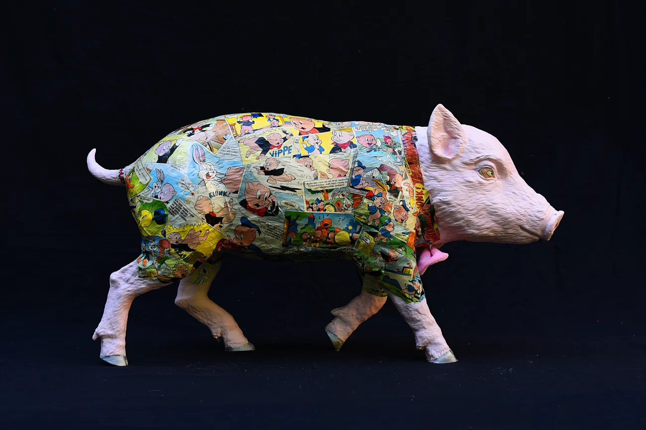 Rosa bemaltes Schwein, bedeckt mit bunten Comic-Motiven