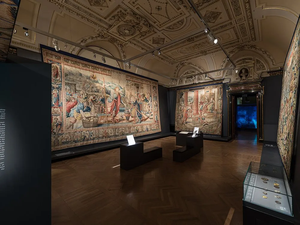 Ausstellungsraum: Gemälde an Wänden, Vitrinen mit antiken Artefakten