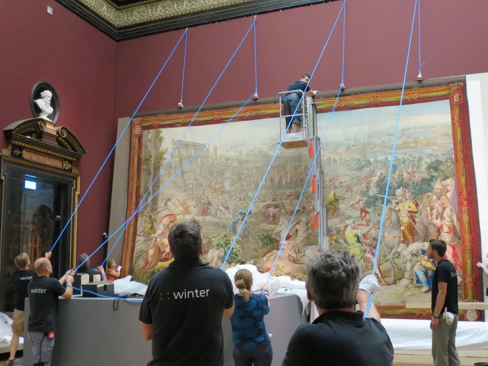 Gruppe an Arbeitern hängen riesen Gemälde in Museumsraum auf