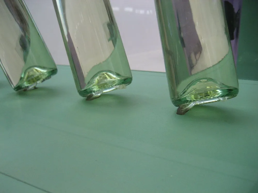 Detailsansicht: Drei Glasflaschen schräg auf Vitrinenboden angebracht