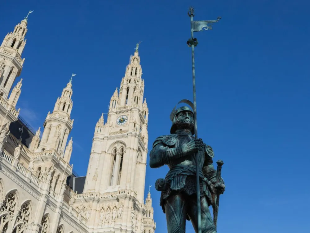 Replika Rathausmann: Aufnahme aus größerer Entfernung mit einer vollständig sichtbaren kleinen Flagge, vor dem Rathaus.
