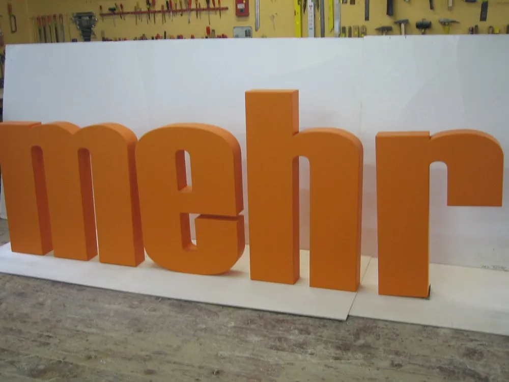 orangene 3D Schrift "mehr" 