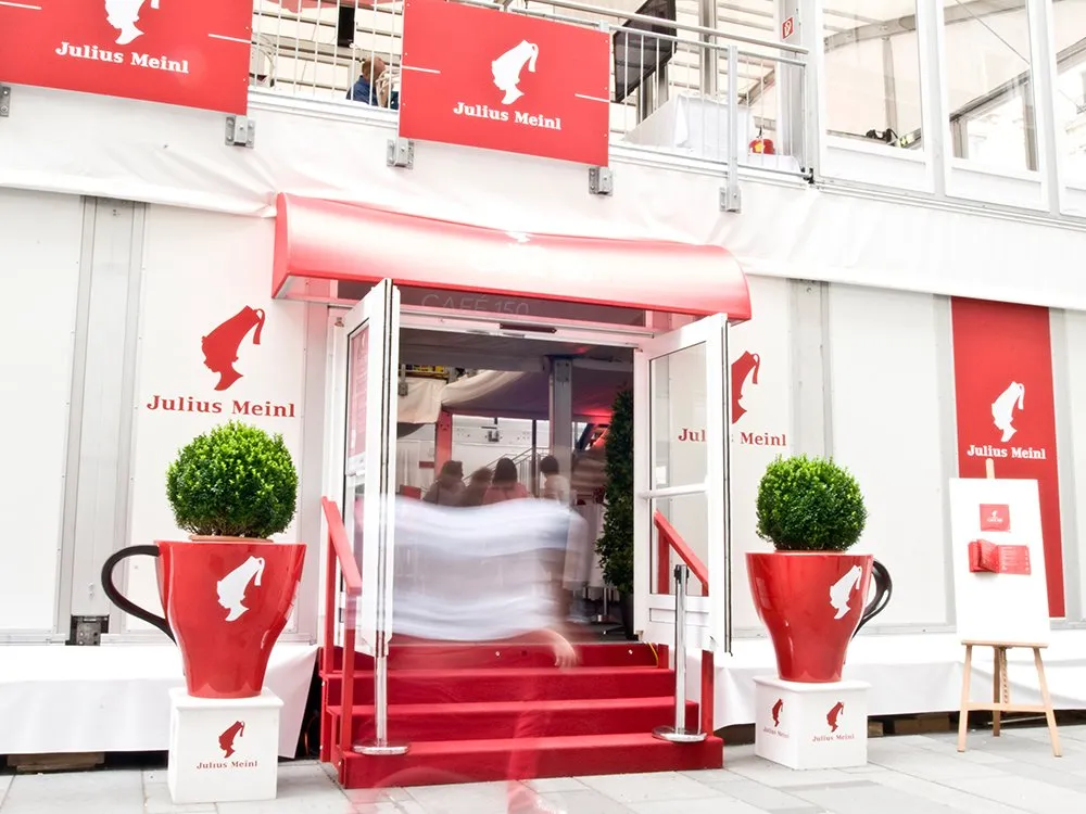 Eingang Julius Meindl Geschäft, Kaffeetassen-Blumentöpfe rechts und links von Tür