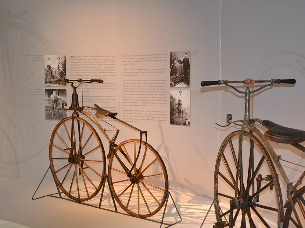 Altes Fahrrad mit hölzernen Rädern, Text und Bilder an Wand